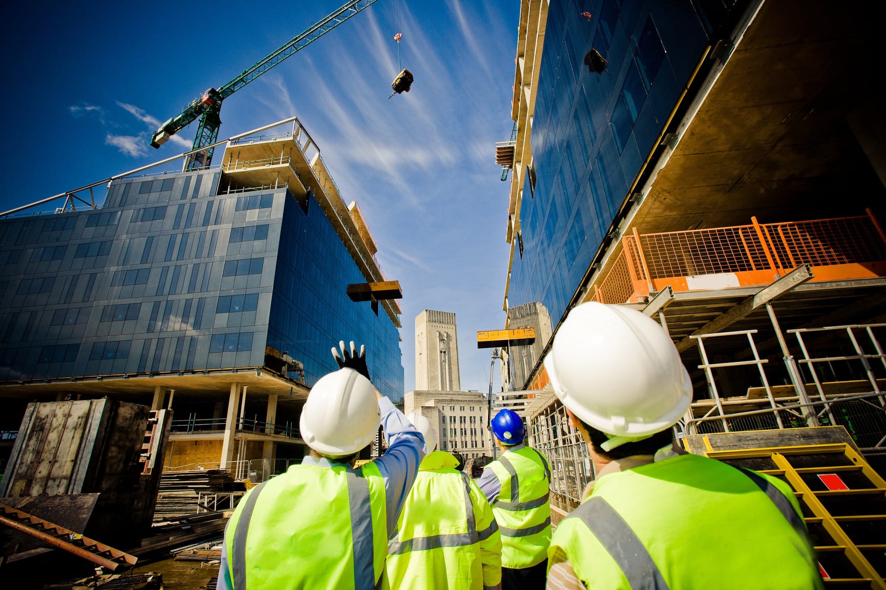 Construction workers looking up at a office building being constructed